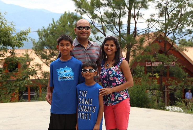 Doctor Patel and his family smiling outdoors