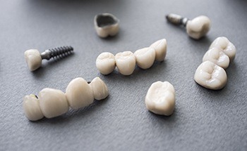 Several dental crowns and bridges attached to dental implants on table