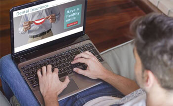 Man looking at dental insurance information on laptop