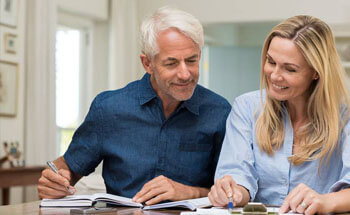 Older man and woman looking at paperwork for dental insurance in Woodstock