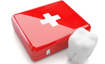 Model of a tooth next to a first aid kit