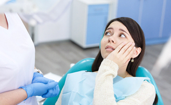 Dental patient with toothache talking to dental professional about tooth extraction