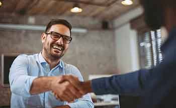 Patient in Woodstock smiling with dental implants at work