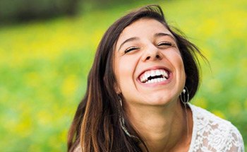 Laughing woman outdoors with dental veneers in Woodstock