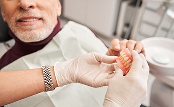 A dentist showing dentures to her patient
