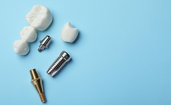 Dental implant and dental bridge parts set against a blue background