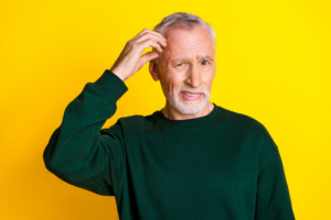 Man scratching his head on a yellow background